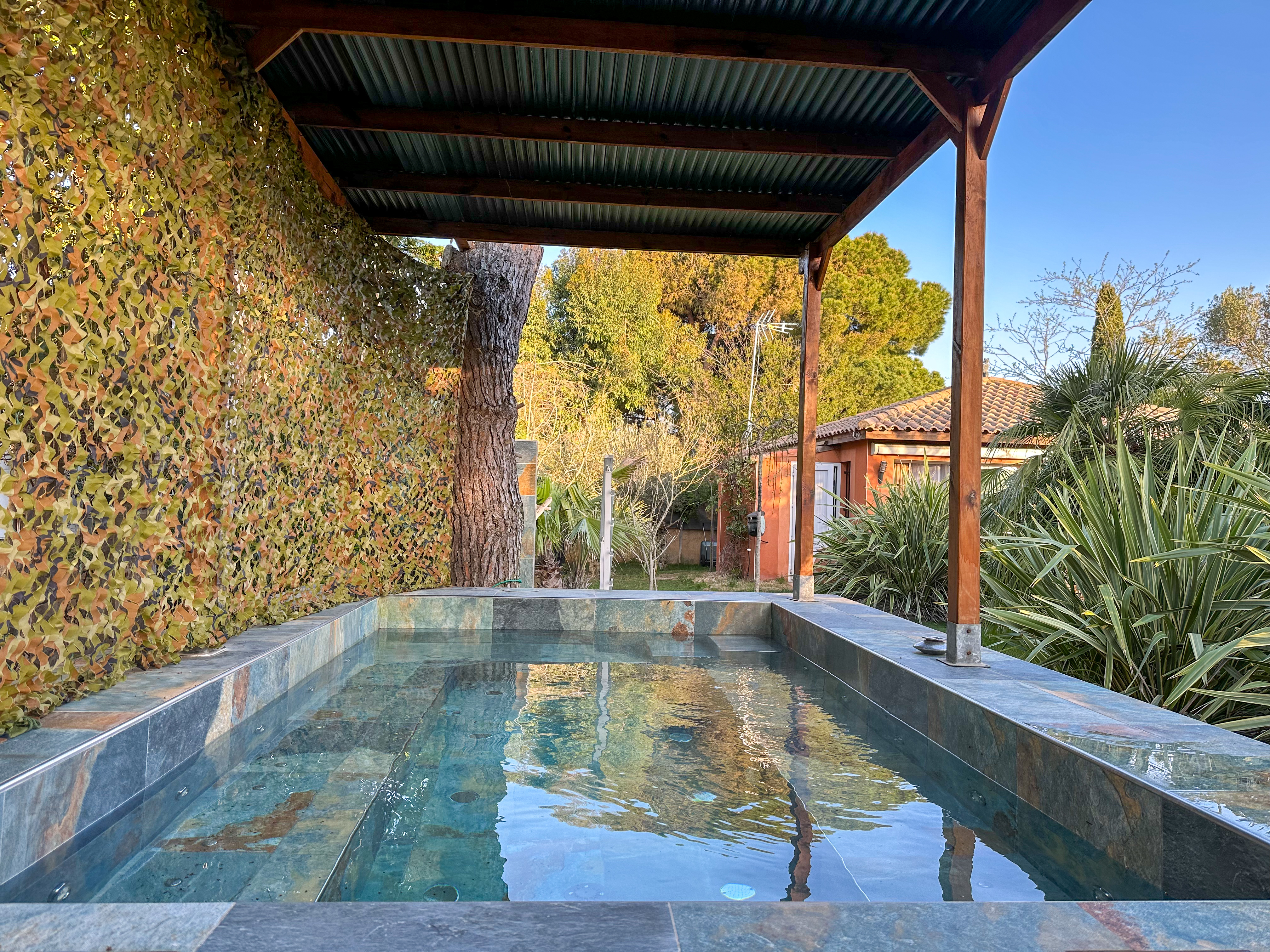 Jacuzzi en pierre de Bali sous pergola en bois