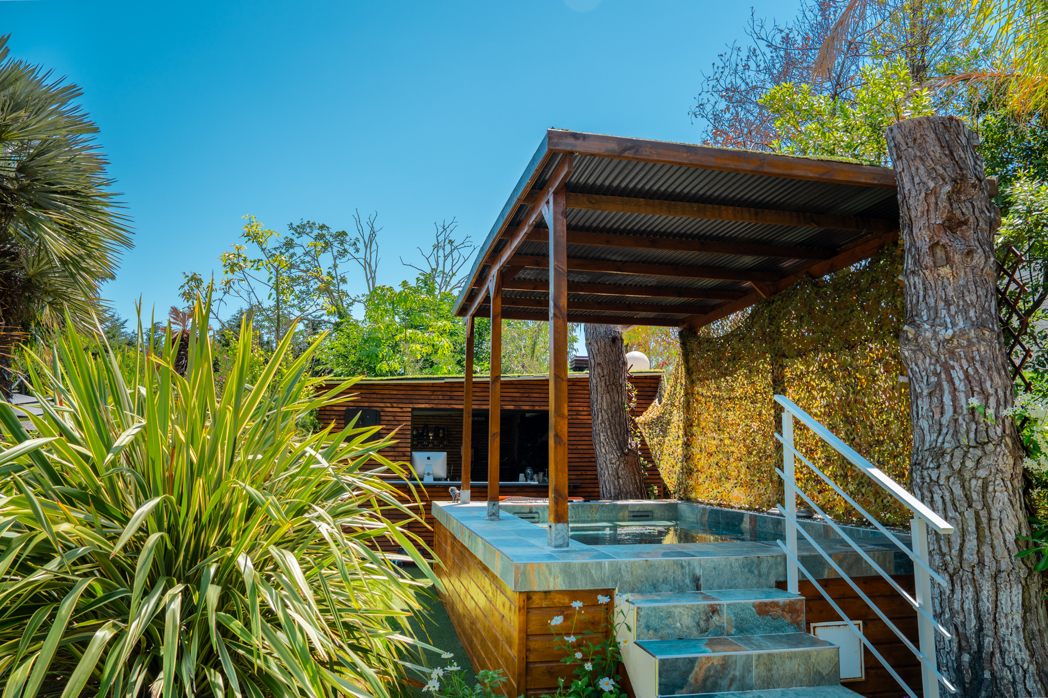 Vue large piscine et jardin luxuriant