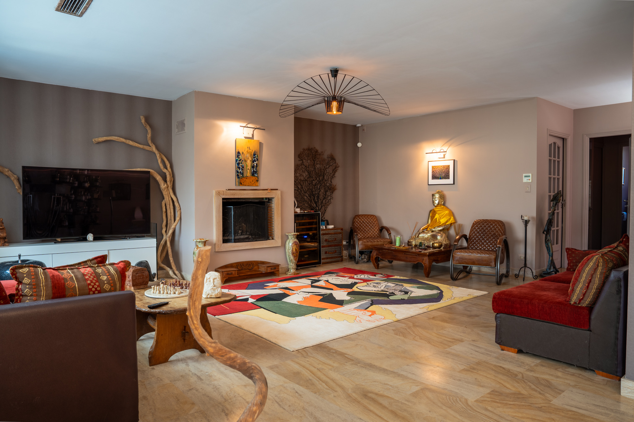 Salon avec TV, cheminée et tapis Picasso coloré